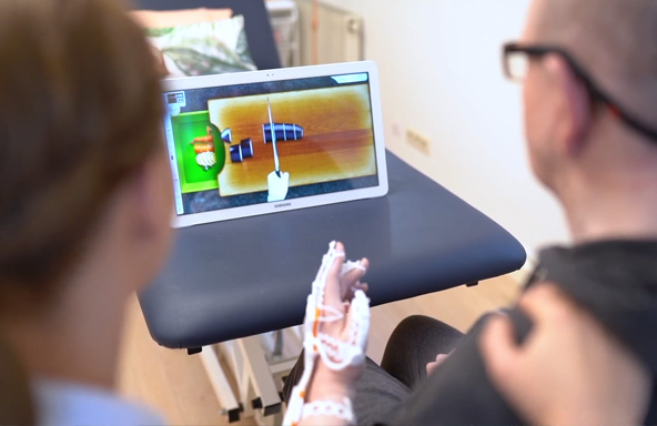 네오펙트 스마트글러브를 끼고 게임에 집중하는 환자